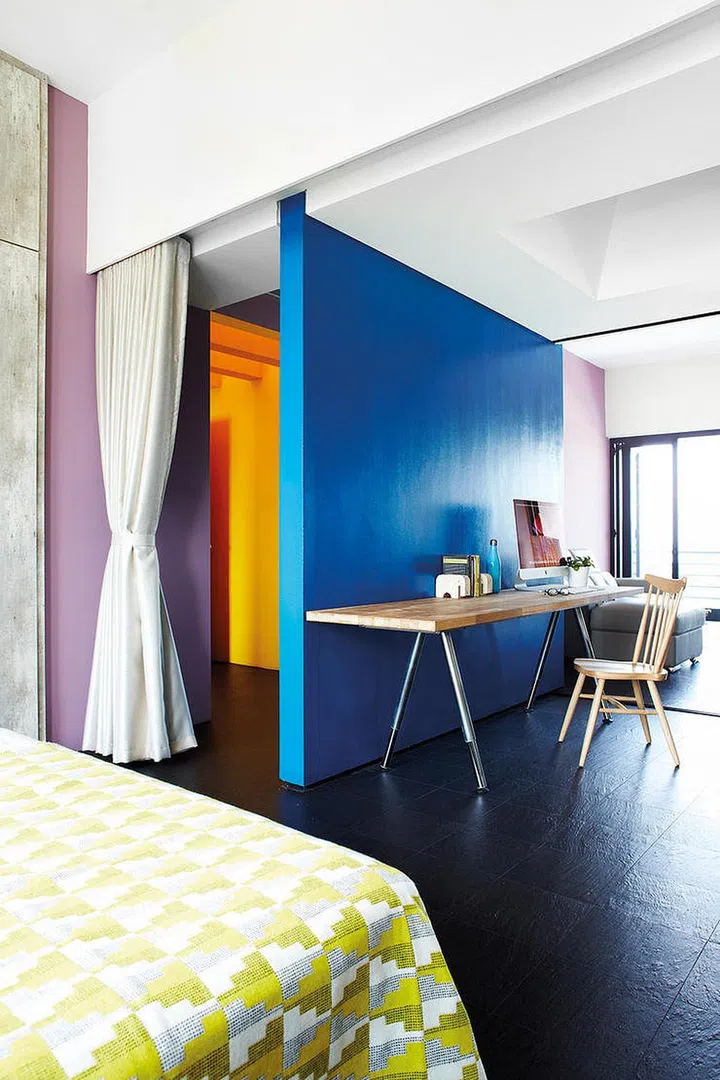 Multi-colour doesn’t have to be gaudy. The three dominant hues of the home – blue, yellow and lilac – are balanced out by the plain black floor and white ceiling.