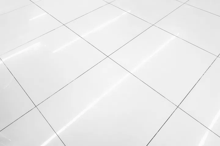 Flooring tile background and reflection of luminaire.