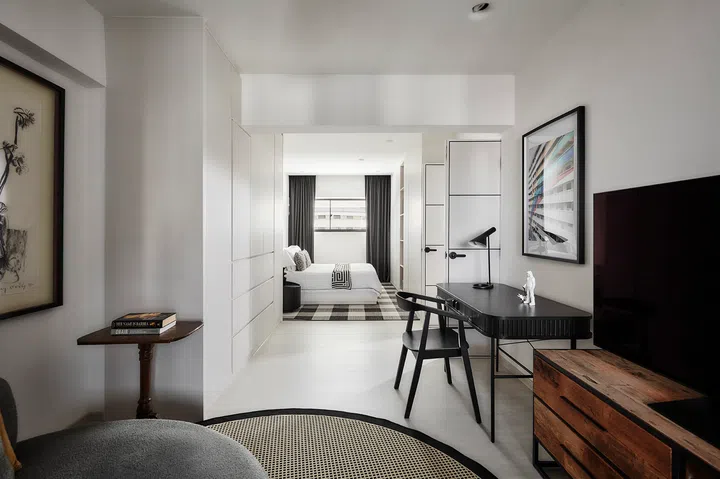 The elongated bedroom separated into two zones, one for resting and the other as a reading nook.