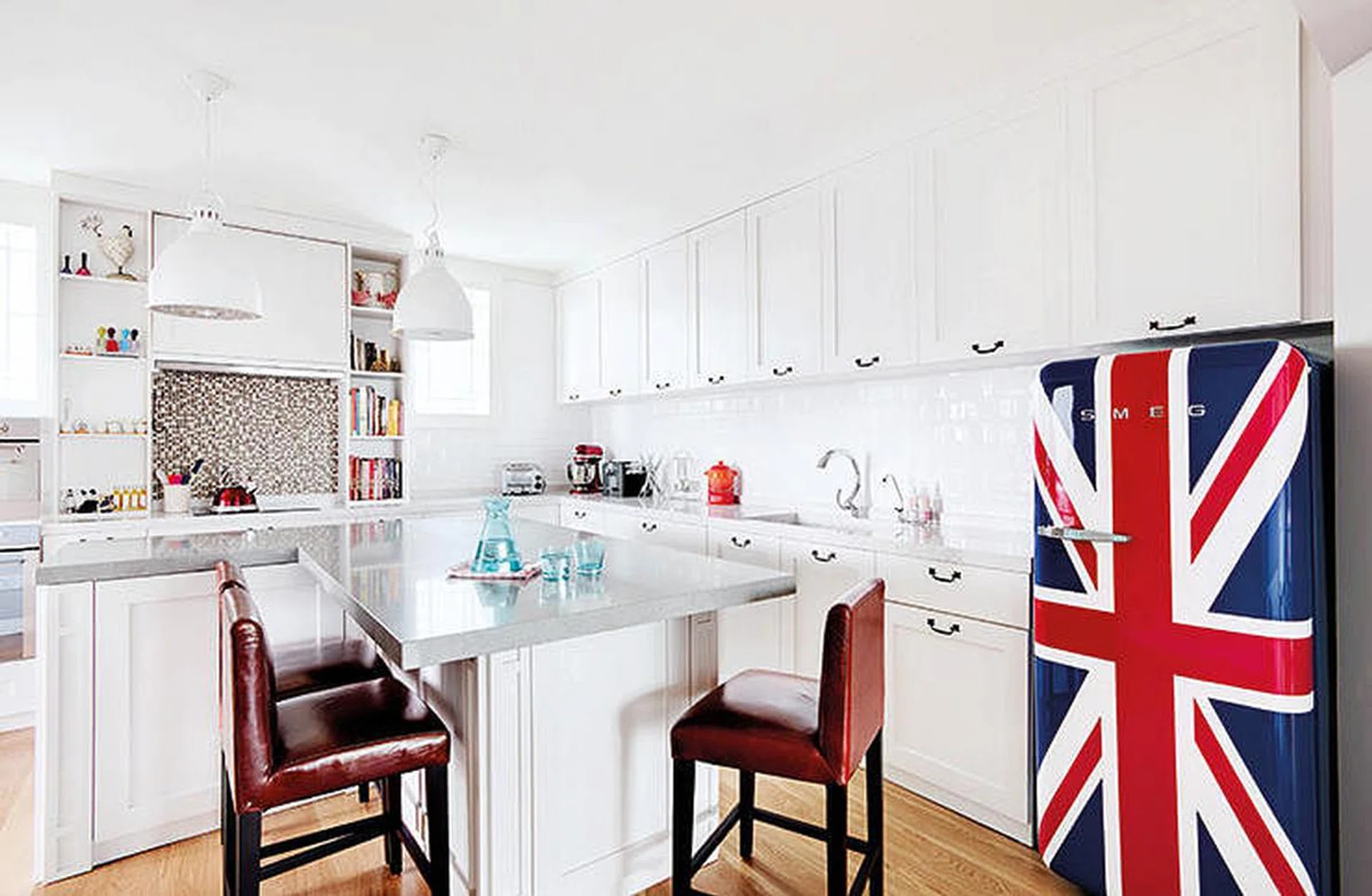 All white kitchen cabinets with a graphic, British flag SMEG fridge. Interior design by Aiden T.