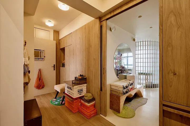 Opening the door reveals the sunlit living space beyond, where glass blocks and sea-facing windows contrast with the foyer’s enclosed calm.