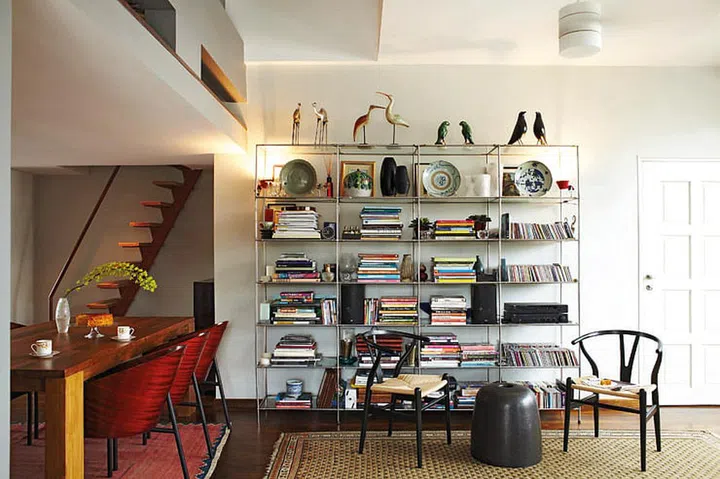 The enlarged living room allows the owner to express his decorative ideas. Warm wooden flooring complements his exotic rugs, while the display shelf showcases his treasured tomes and rare souvenirs.