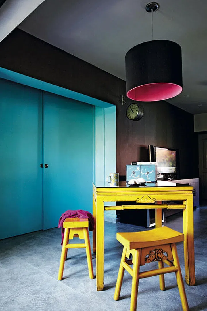 Quirky details like a brown lamp with a hot pink interior, Chinese floral-print tableware and vintage clocks add to this home's charm.