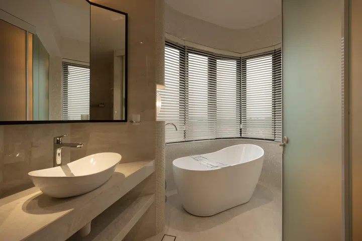 Once a balcony, the bathtub area is now part of a calm, monolithic white space designed as a place to unwind after school.