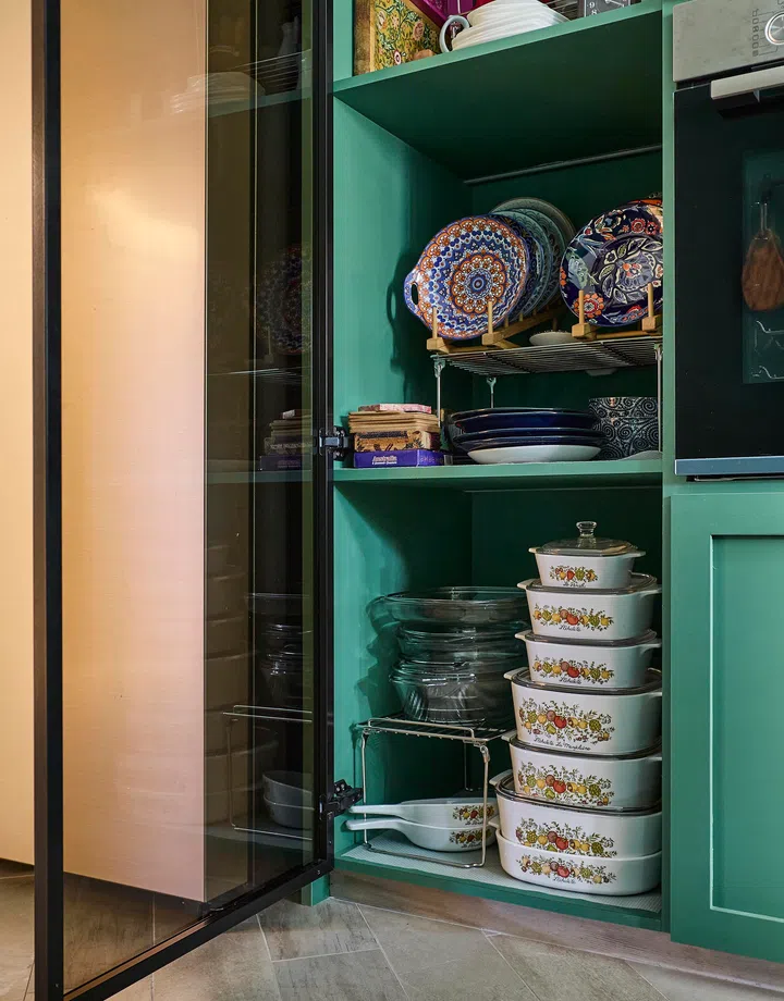 Vintage Corelle dishes and patterned ceramics neatly displayed in a glass-fronted cabinet in a 4-room HDB resale in Sunset Way.