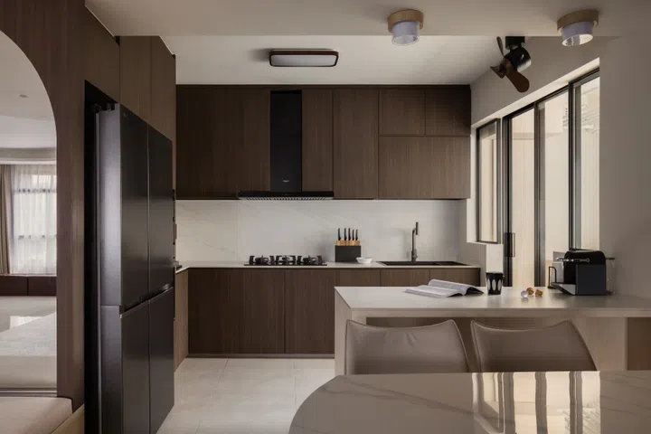 Dark walnut cabinetry echoes the TV console and feature arch, creating a cohesive palette throughout the home.