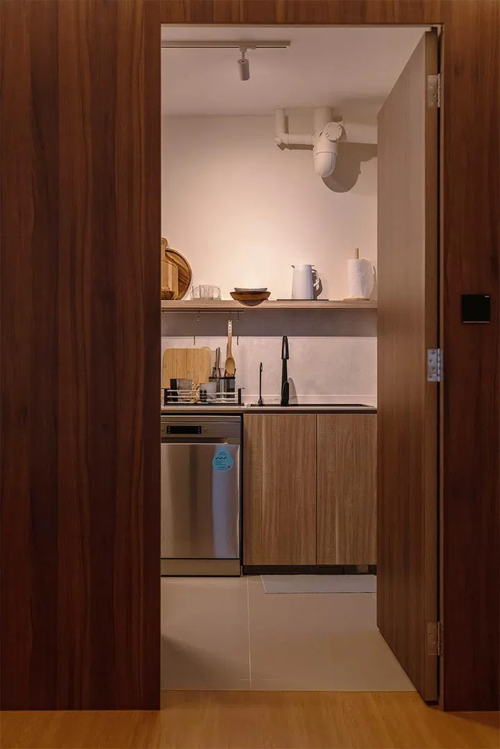 A concealed entry and matching wood finishes allow the kitchen to blend seamlessly into the surrounding dining area.