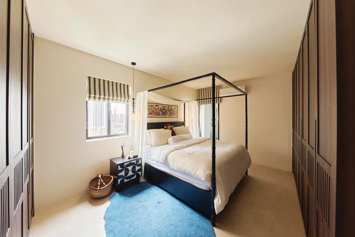 A king-sized four poster bed sits in the master bedroom of a 3-bedroom condo (1,800 sq ft) in Pandan Valley, designed by Insight.Out Studio.