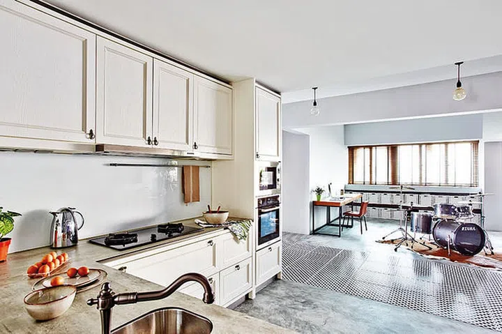 The tiled flooring in the living area acts as a rug. demarcating the open-plan kitchen from the study and storage area opposite. 