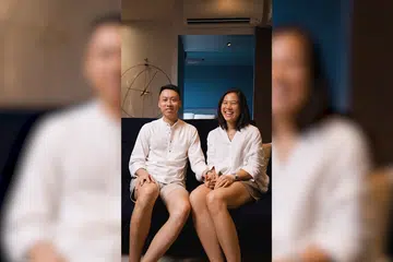 Homeowners of a 4-room HDB BTO in Dakota, Jovina, and Zheng Xiang, poses for a photo on their sofa in the living room.