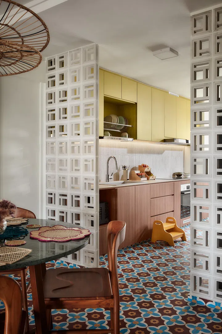 Breeze block screens frame the kitchen beyond, allowing light and views to pass through while maintaining separation.