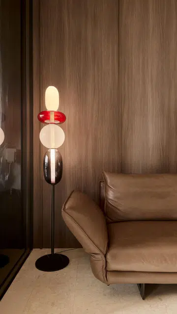 A floor lamp by a leather sofa in a 840 sq ft 2-bedroom condominium at Hillview Rise.