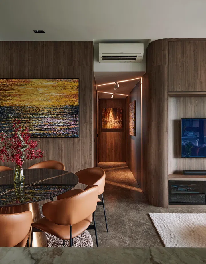 A softly illuminated corridor view from the living room, where architectural lighting and concealed storage enrich the home’s quiet sophistication.