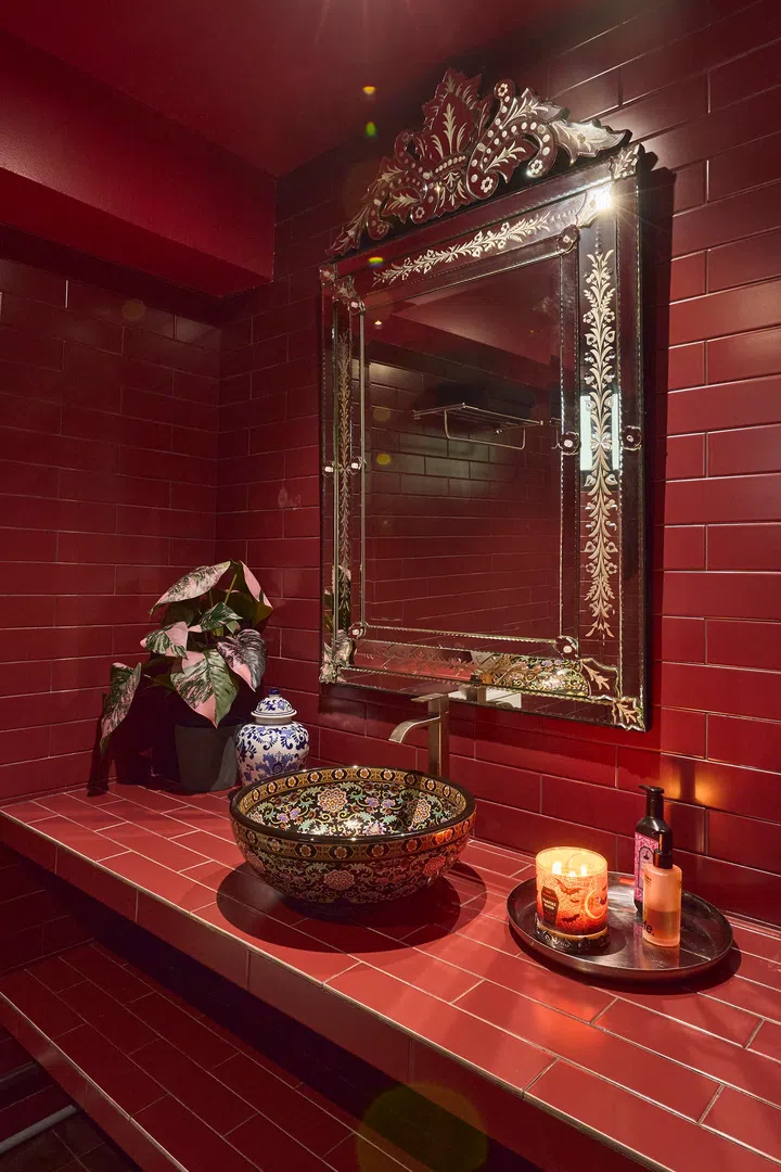 A porcelain vessel sink and ornate mirror introduce contrast against the richly tiled backdrop.