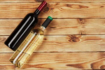 bottle of wine over wooden background