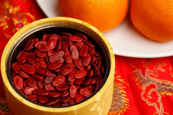 Red 'lucky' melon seeds in container for Chinese New Year. Photo 123RF