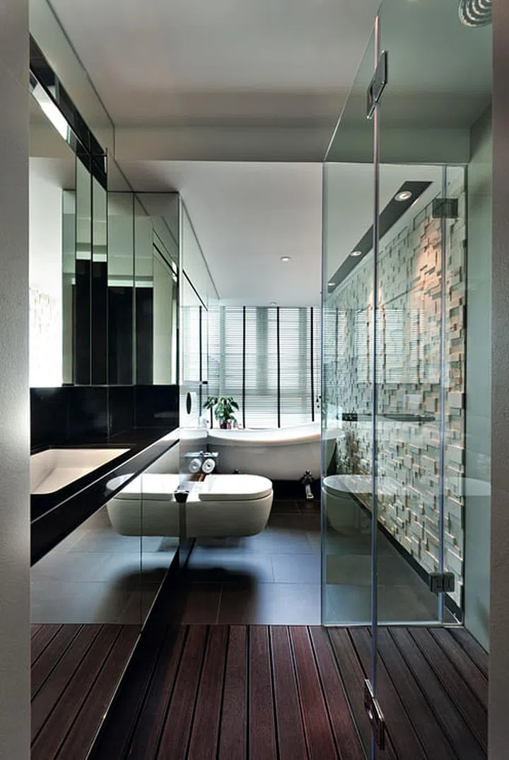 Mirrors and a glass-enclosed shower give the small master bathroom a more spacious look.