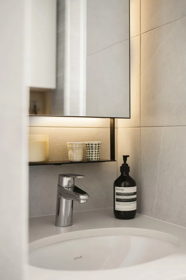 Simple fittings and integrated lighting keep the common bathroom functional and uncluttered, allowing it to age gracefully over time.