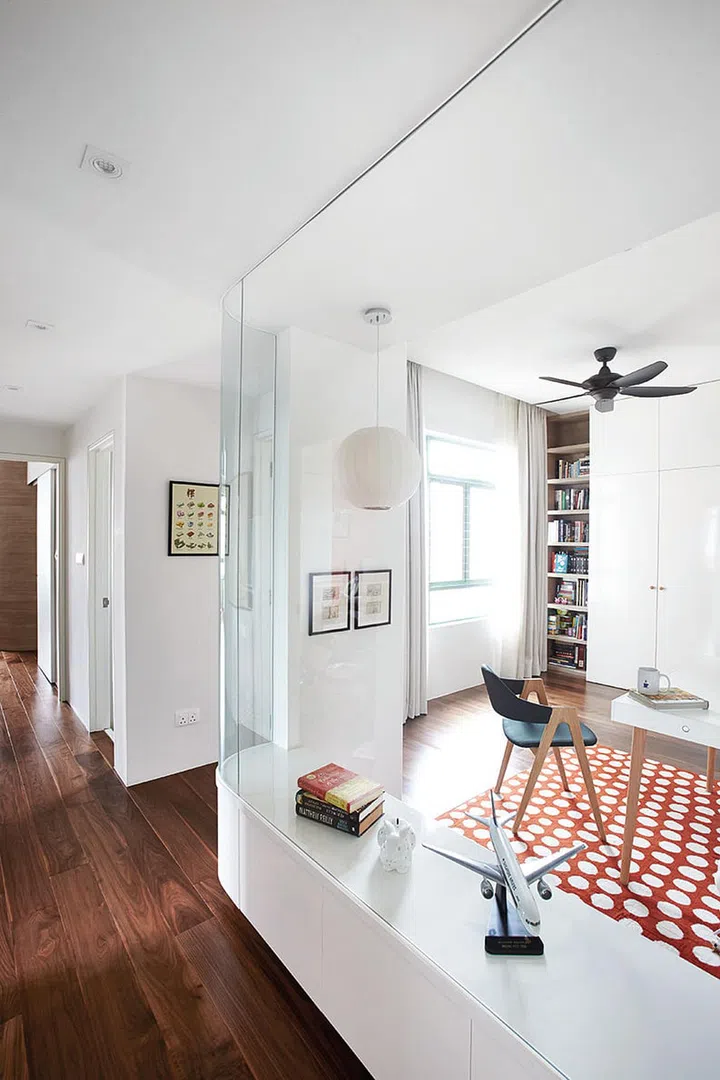 The pod-like glass wall of the study lets in natural light and visually extends the spaces. The bench was created so that it could be converted into a platform bed when the children eventually need their own rooms. Interior design by EHKA Studio