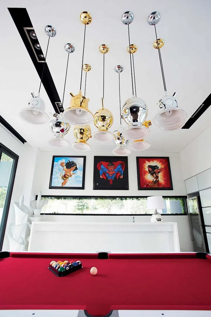 Glitzy mouth-blown bell-shaped glass pendant lamps hang from the high double-volume ceiling, catching the eye of the beholder.