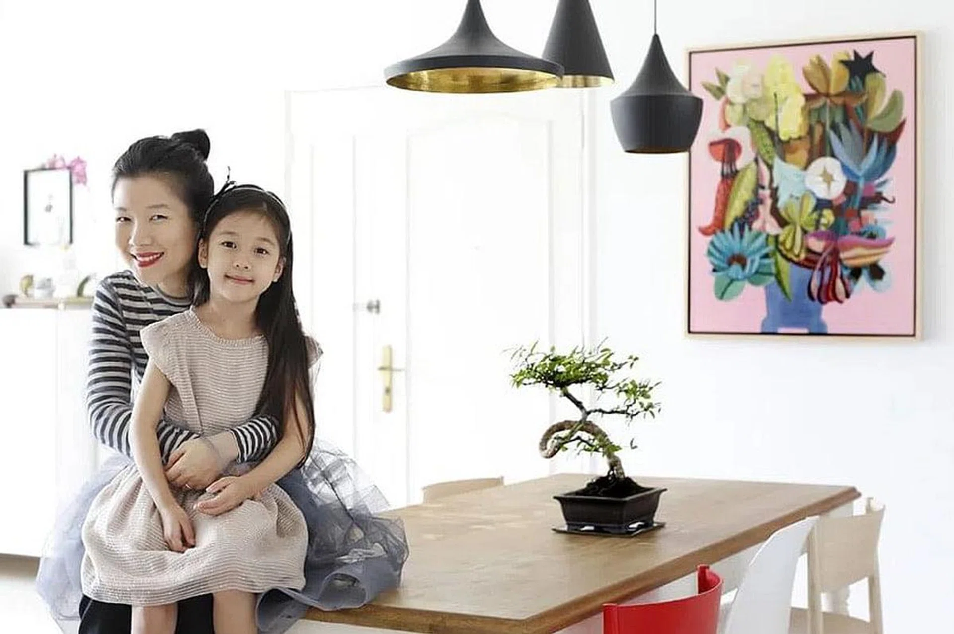 Gallerist Lim Ju Lynn and her daughter posing in their all-white 3-bedroom Bukit Timah condominium filled with art.