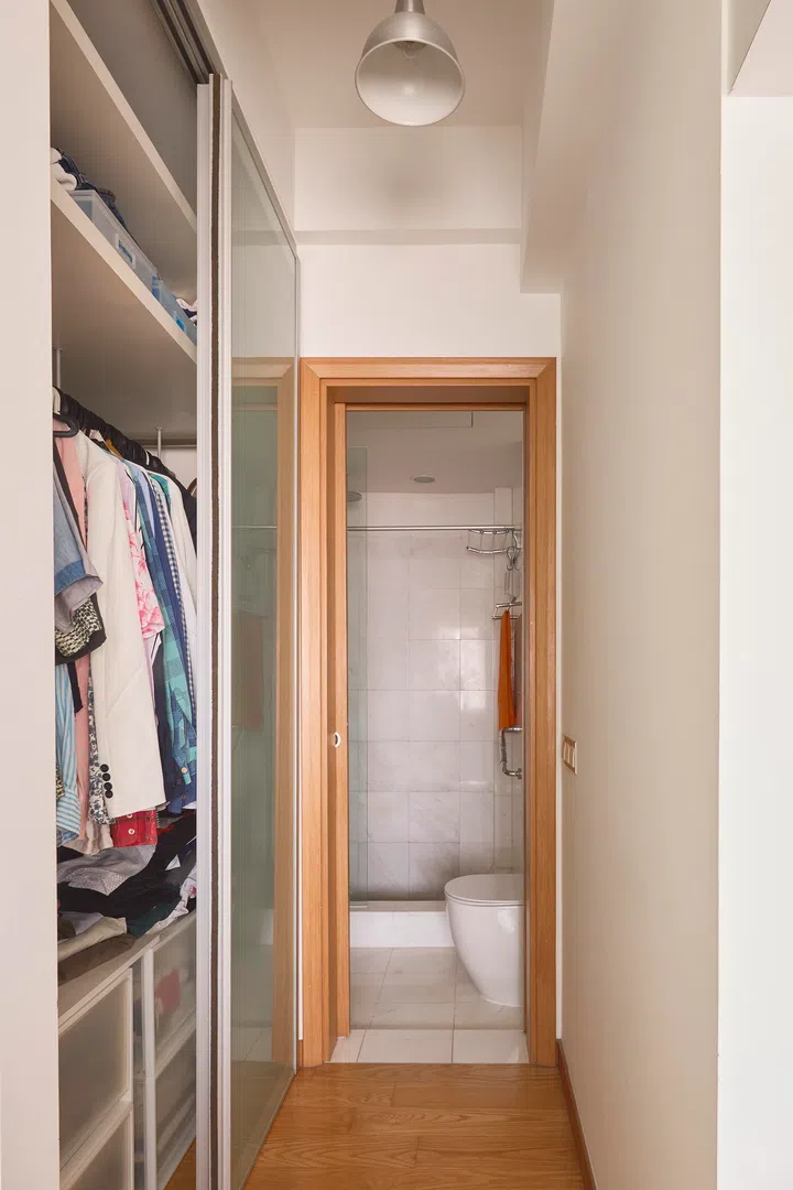 A compact corridor leads from the bedroom to the bathroom, featuring an integrated wardrobe which keeps storage and circulation neatly contained.