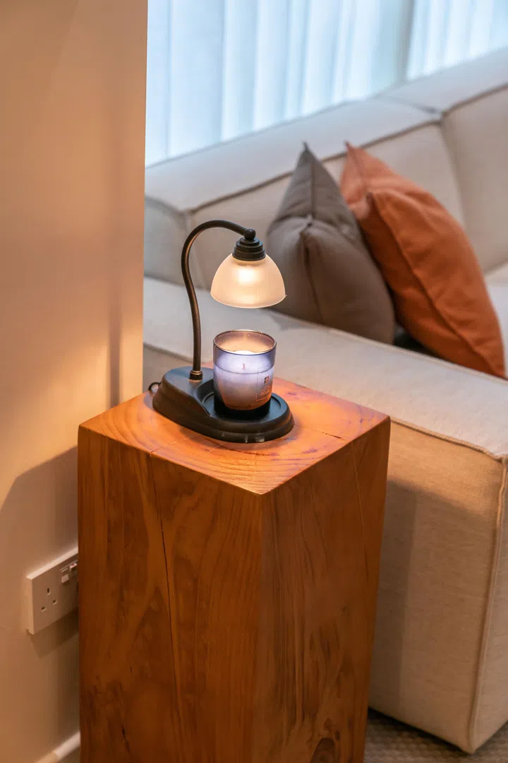 A small candle warmer adds ambient glow and a subtle scent to the bedroom, reinforcing the home’s calming, restful tone.
