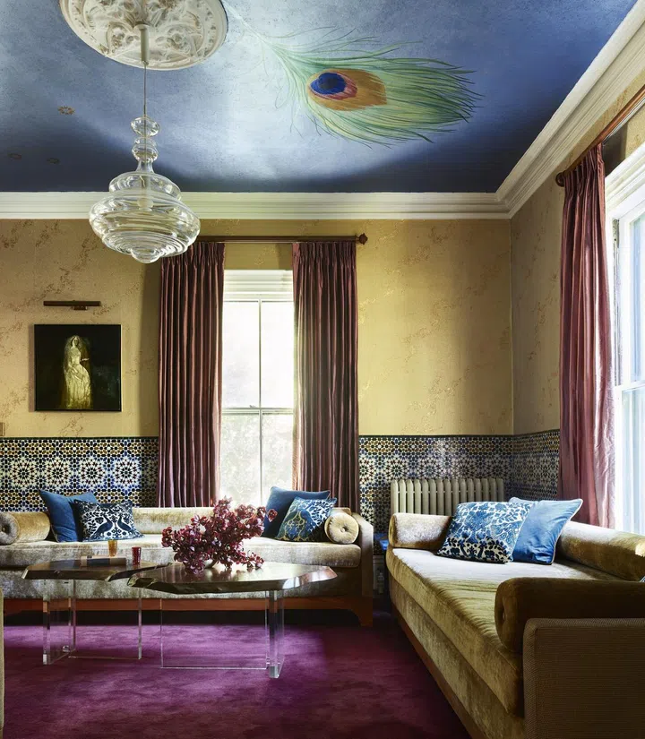 A maximalist living room with purple carpets, yellow wainscot walls, and blue ceilings. Interior Design by Sashya Thind. Photo by Jared Kuzia