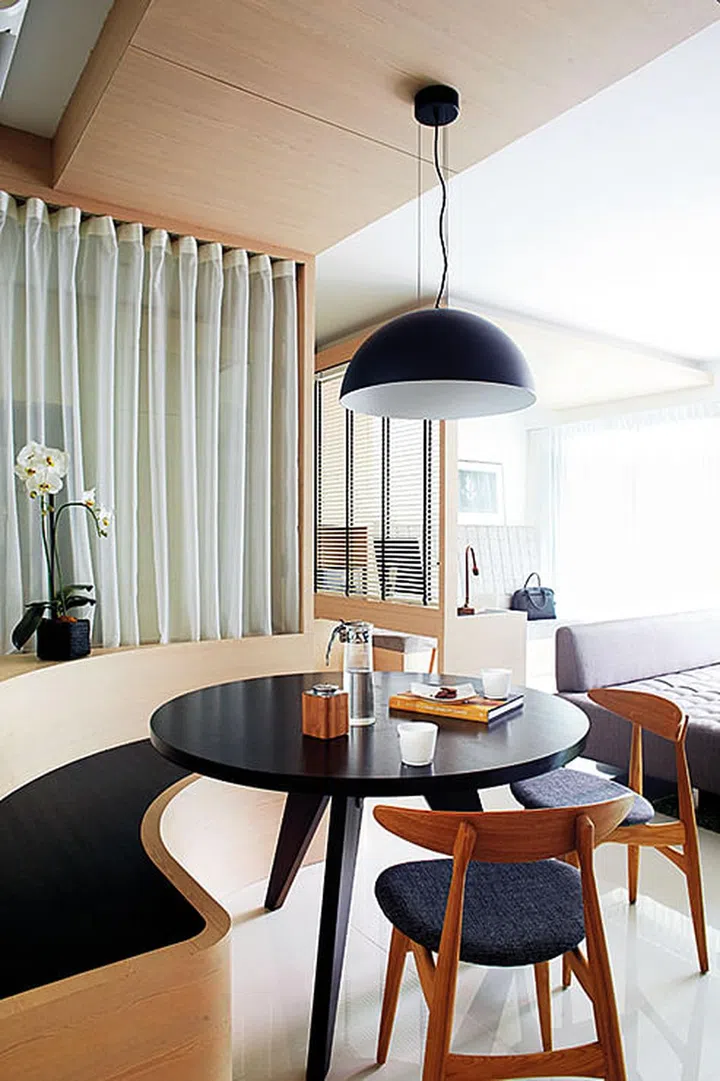 Sheer curtains are used to divide the dining area from the kitchen, while still allowing light to pass through.