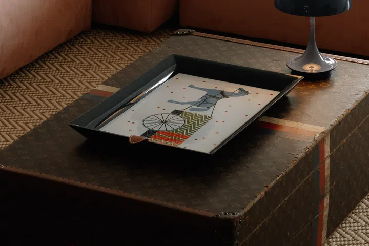 A vintage Louis Vuitton trunk finds new life as a coffee table, paired with a Louis Poulsen Panthella portable lamp that reflects the couple’s appreciation for timeless European design.