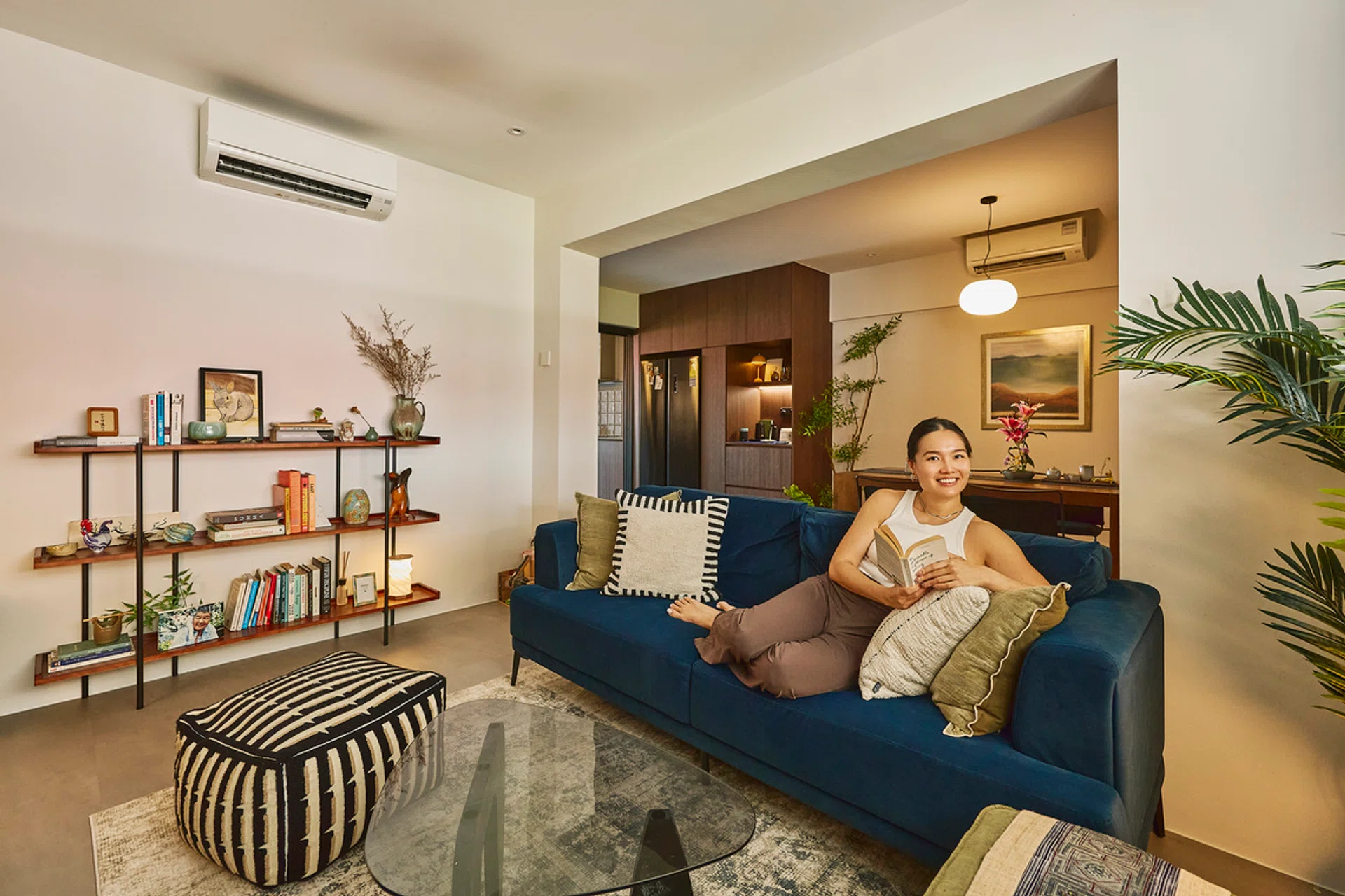A social service professional in her 30s poses for a photograph in the living room of her 3-room HDB flat in Potong Pasir (797 sq ft), designed by TALA Design + LLP.
