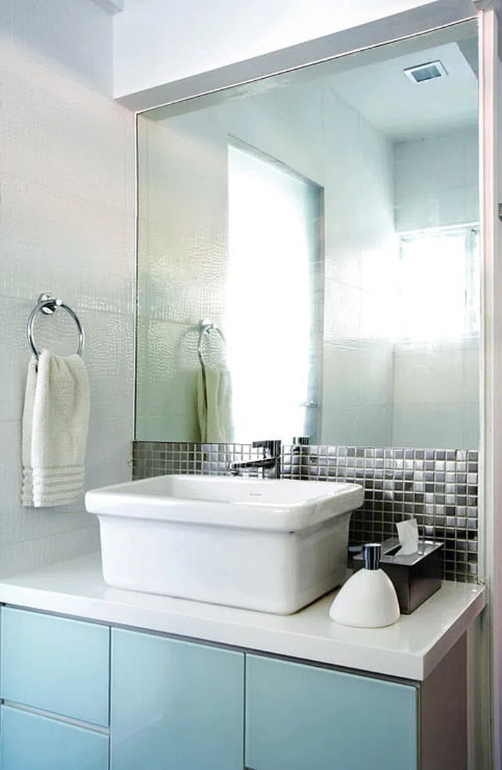 In contrast with the bright-coloured living spaces, the bathroom is simpler with its white and silver scheme.