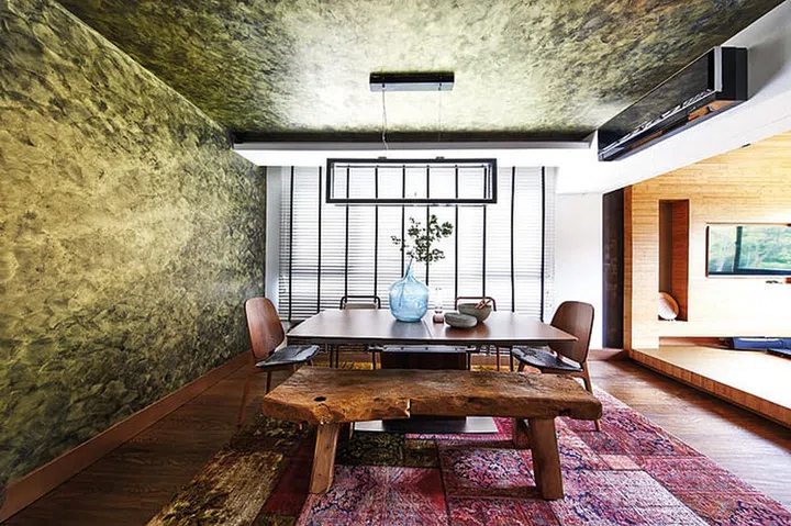 The dining set consists of mismatched seats - a customised wooden bench, and chairs from Om and Marquis. Blue vase and tableware from Stylodeco.