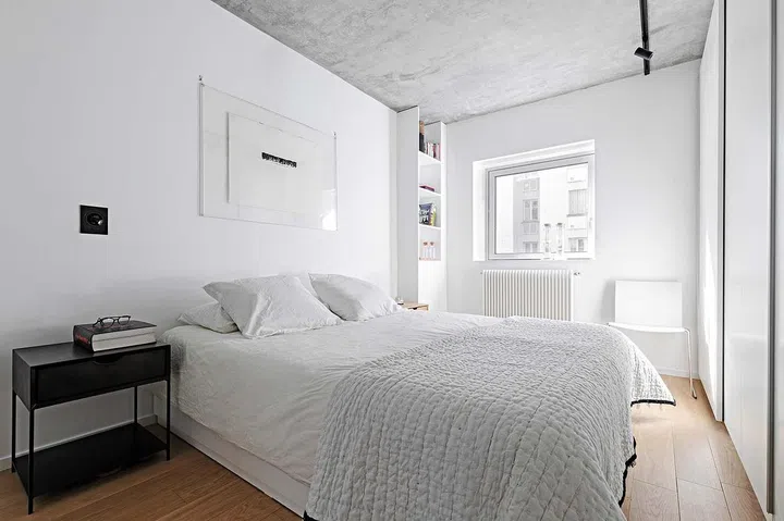 The bedroom, draped in white, creates a contemporary atmosphere.