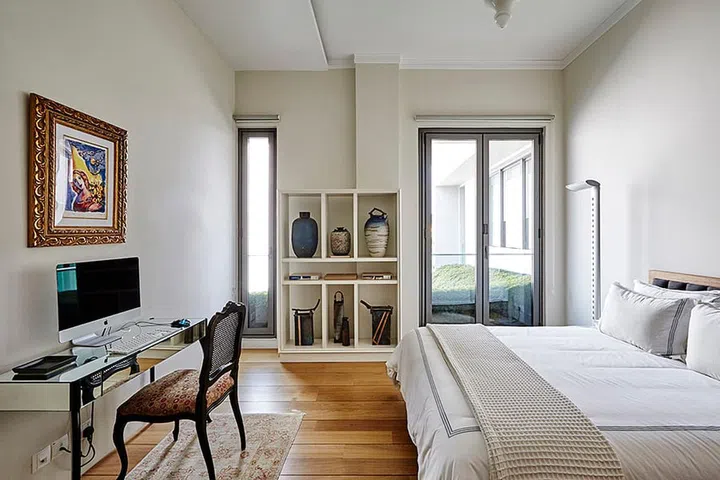 The greenery and light, which the guest bedroom opens up to, make the space welcoming and inviting.