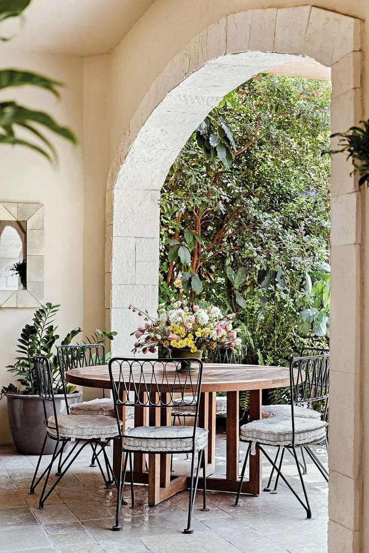 The covered terrace is directly connected to the garden surrounded by vegetation.