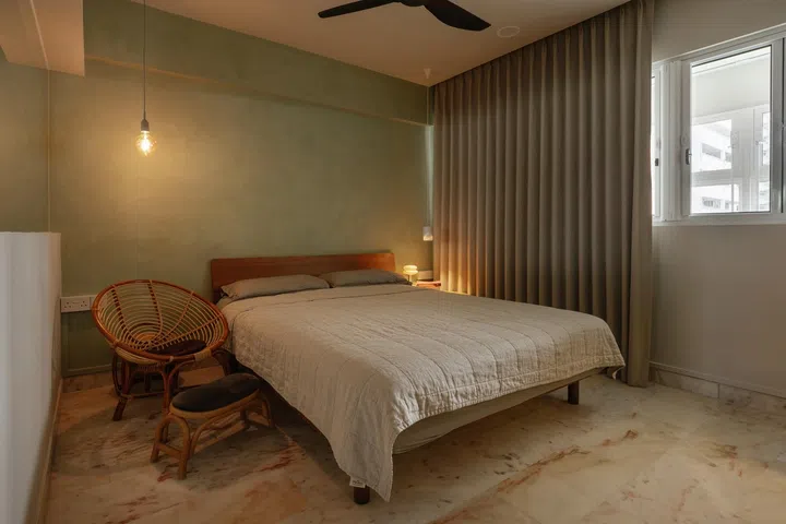 A olive-toned limewash wall behind the bed adds depth and softness to the space.