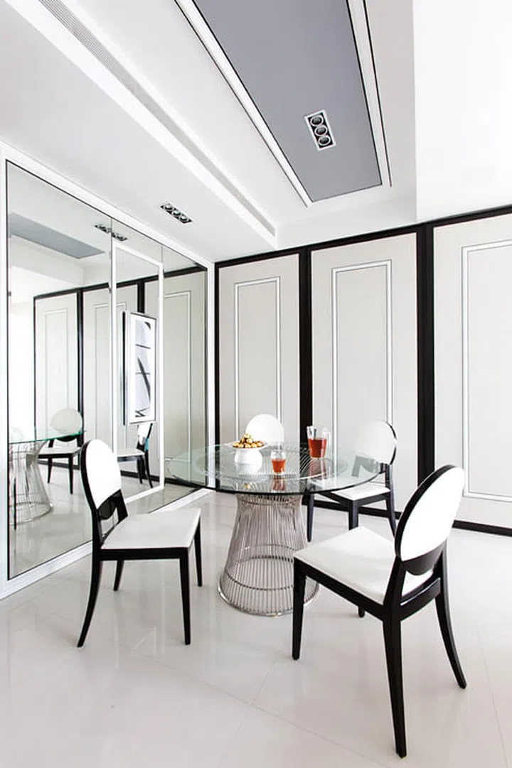 Thin black borders on the creamy wall panels and dining chairs bring out their clean simplicity.
