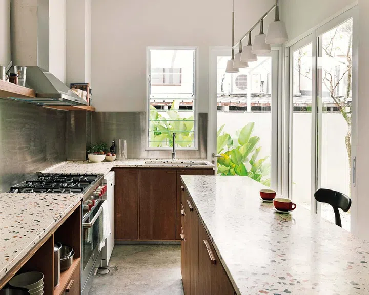 The bare
marine ply,
natural terrazzo
counters and
stainless steel
backsplash all
pay homage
to mid-century
living.