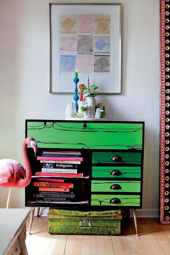 The homeowner painted the living room’s retro-style storage unit a lively green, and her friend helped add black wood patterns.