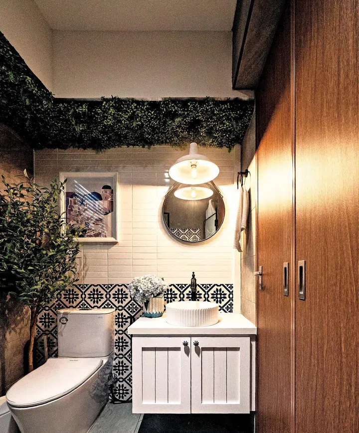 The patterned wall tiles, seen at the water fountain, liven up the grey surfaces that the homeowners want for their master bathroom.