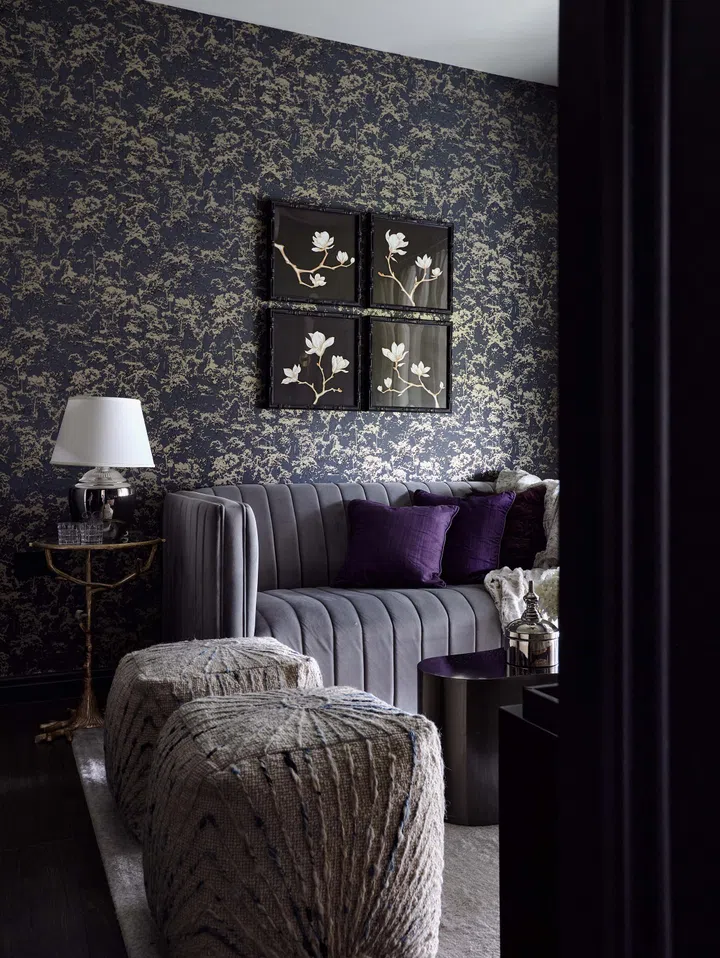 The feature wall, with its velvety blue hue and subtle sheen, adds depth while cleverly hiding storage.