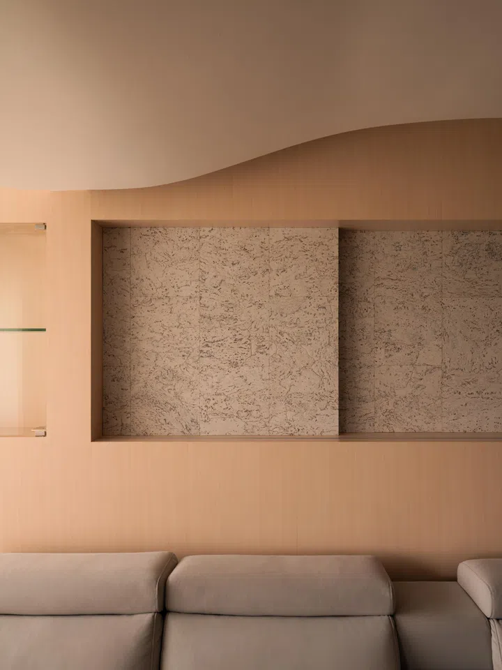 A recessed niche is set within the feature wall, framing the seating area while keeping surfaces visually quiet and uncluttered.