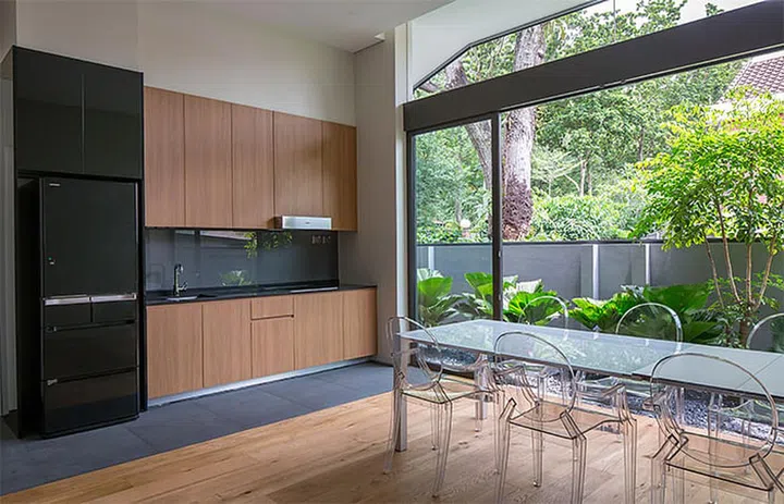 The dry kitchen is kept clean and simple, and is furnished with a long glass table in this semi-detached house in Trevose Place, Bukit Timah.