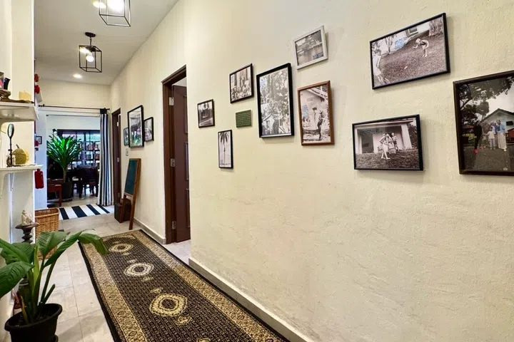 An ornate runner rug brings warmth to the corridor, where a gallery wall of historic photos and preserved insect specimens invites guests to slow down and explore each story.