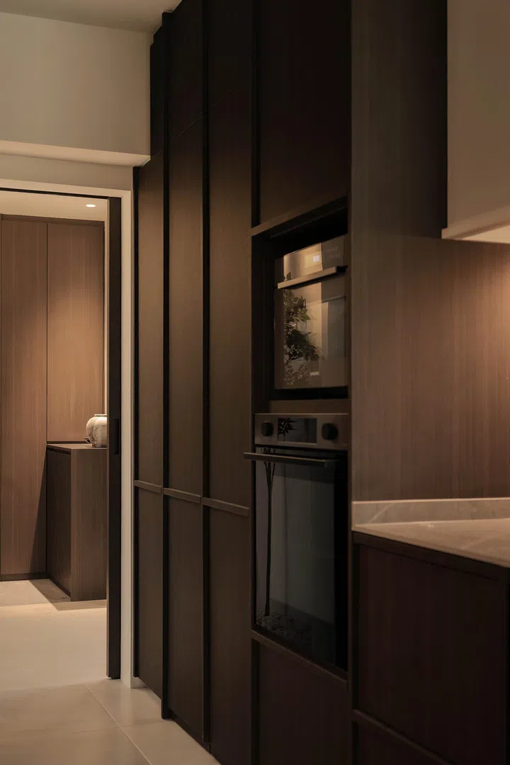  Under-cabinet lighting highlights the stone-look counters, adding warmth to the dark, minimalist kitchen.
