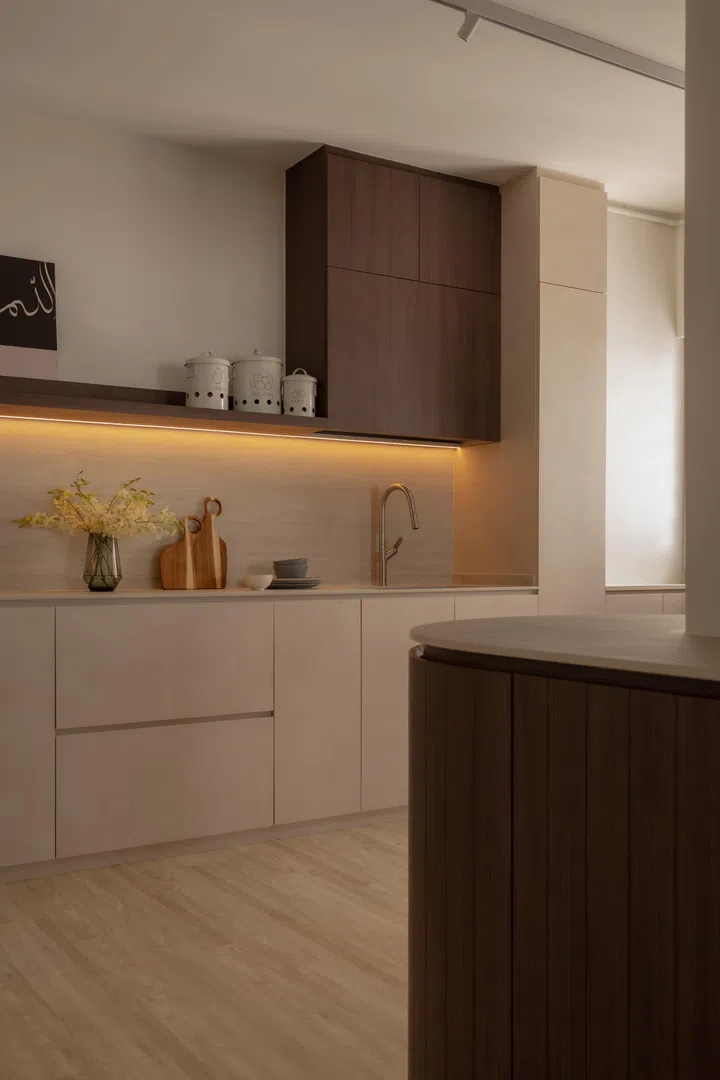 In the kitchen, open shelving replaces heavy upper cabinets, keeping the space light and visually connected to the rest of the home.