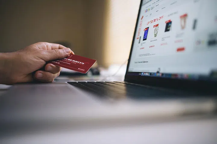 guy holding credit card and online shopping