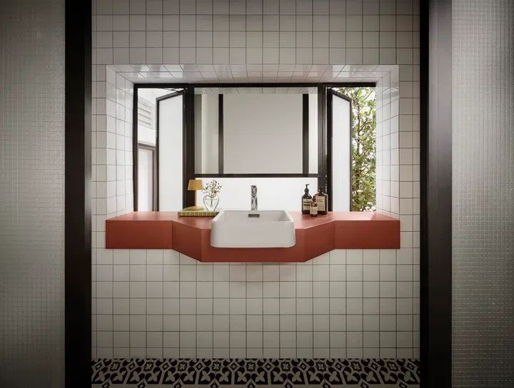 A customised terracotta-toned basin was designed to echo the retro character of the Tiong Bahru estate, grounding the bathroom in the home’s history.