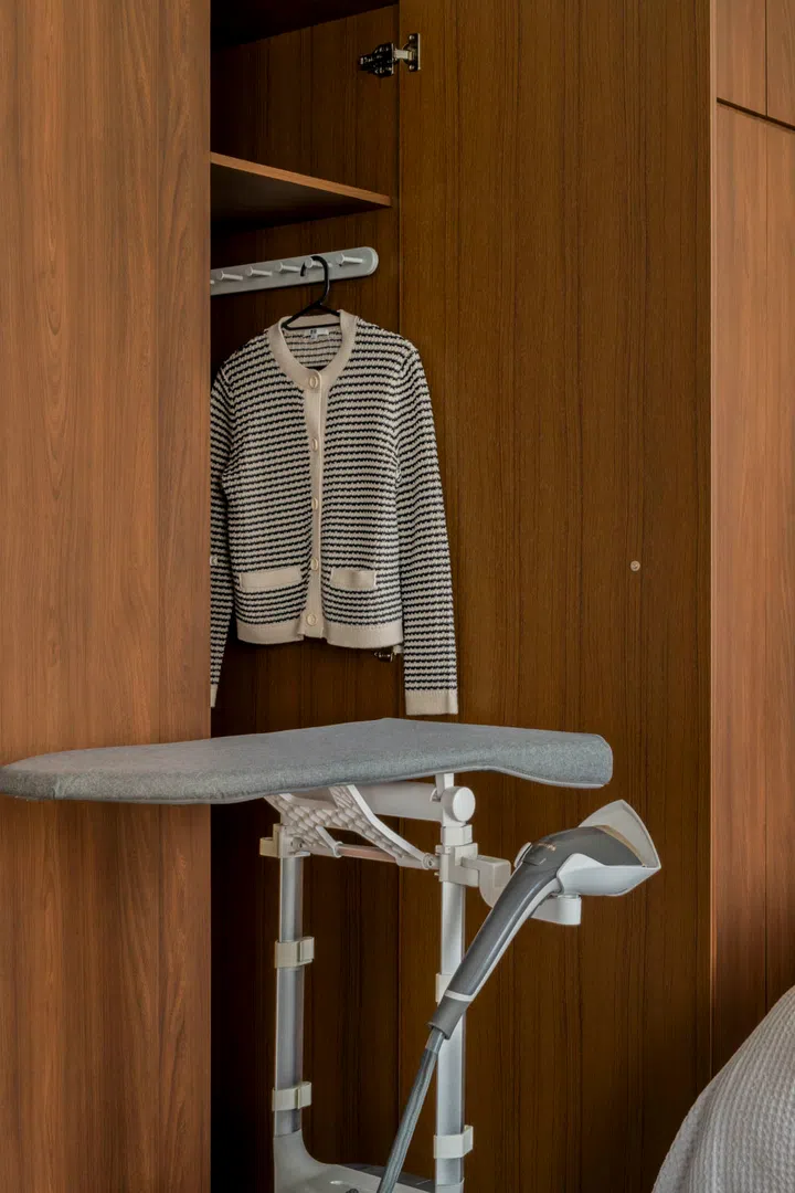 Even the ironing board folds away into built-in storage—proof of the home’s space efficiency.